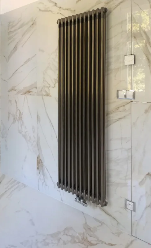 Designový článkový radiátor na mramorové stěně